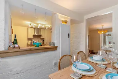 a dining room with a table with plates and wine glasses at Low Tide Bedford Rd Boutiques in St Ives