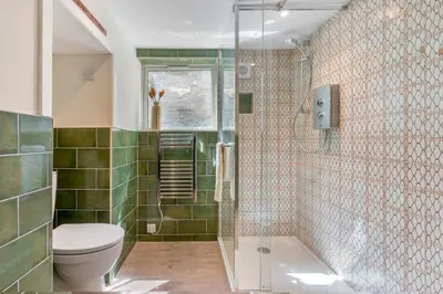 a bathroom with a toilet and a glass shower at Low Tide Bedford Rd Boutiques in St Ives