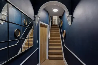 a hallway with blue walls and stairs in a house at Low Tide Bedford Rd Boutiques in St Ives
