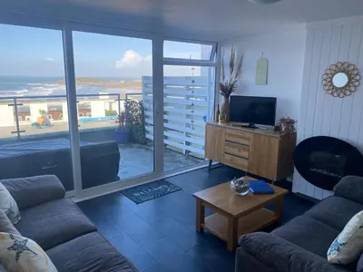 a living room with a couch and a television at Stunning Sea View Apartment in Newquay with 2 Heated Pools in Crantock