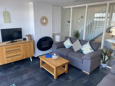 a living room with a couch and a coffee table at Stunning Sea View Apartment in Newquay with 2 Heated Pools in Crantock