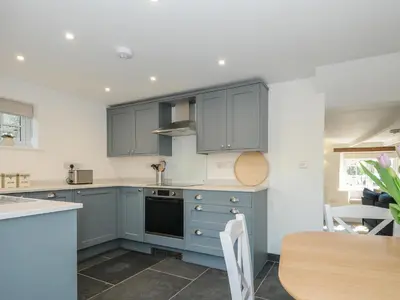 a kitchen with blue cabinets and a table at Sunrise Cottage in Bodmin