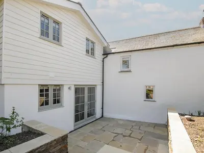 a white house with a patio next to it at Sunrise Cottage in Bodmin