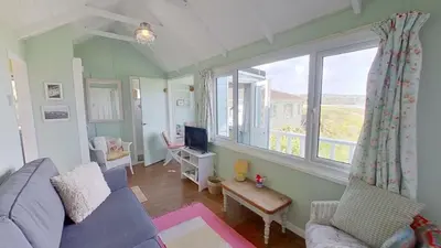 a living room with a blue couch and a window at B18 Sandford, Riviere Towans in Hayle