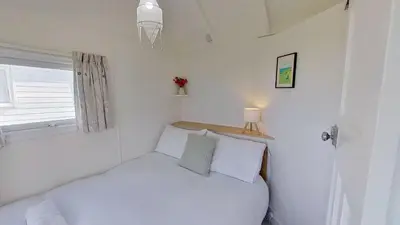 a small bedroom with a bed and a window at B18 Sandford, Riviere Towans in Hayle