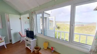 a room with a large window with a television at B18 Sandford, Riviere Towans in Hayle