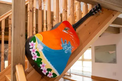 a guitar on the stairs of a house at Stylish Cottage - Walk to Beach & Pubs & Fast WiFi in St. Agnes