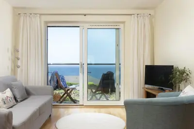 a living room with a couch and a large window at Spectacular Sea Views, Wi-Fi, Parking in Carbis Bay