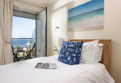 a bedroom with a bed with a view of the ocean at Spectacular Sea Views, Wi-Fi, Parking in Carbis Bay