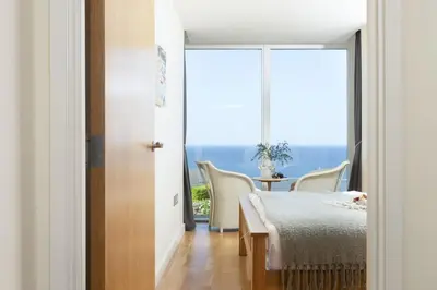 a room with a bed and a table with chairs at Spectacular Sea Views, Wi-Fi, Parking in Carbis Bay