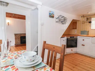 a kitchen with a table with a cup and a bowl at Teana Cottage in Looe