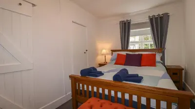 a bedroom with a bed with blue towels on it at Teana Cottage in Looe