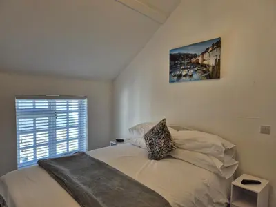a bedroom with a bed with a picture on the wall at OXOX - Room Only Accommodation in Polperro