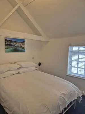 a bedroom with a white bed and a window at OXOX - Room Only Accommodation in Polperro