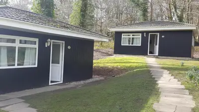 a black house with a white door and a yard at St. Ives Holiday Village in St Ives