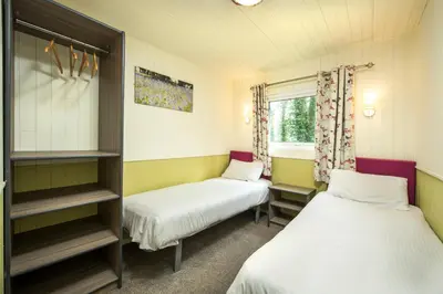a room with two beds and a window at St. Ives Holiday Village in St Ives