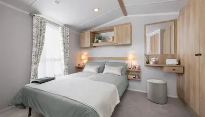 a bedroom with a large bed and a window at St. Ives Holiday Village in St Ives