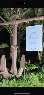 a statue of a cross in the grass with a sign at The Balnoon Inn B&B in St Ives