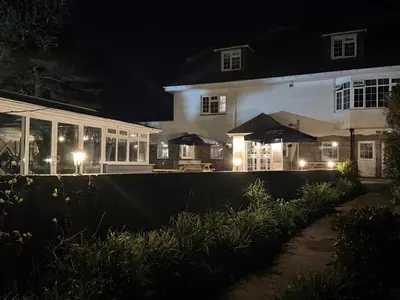 a large white house at night with lights at The Balnoon Inn B&B in St Ives