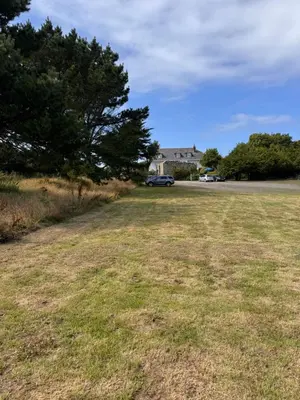 a field of grass with a car parked in the distance at The Balnoon Inn B&B in St Ives
