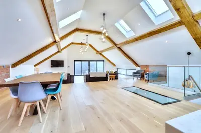 a dining room and living room with a wooden table and chairs at Keynvor View in Port Isaac