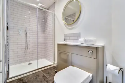 a bathroom with a toilet and a shower and a mirror at Keynvor View in Port Isaac