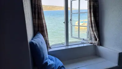 a window with a view of the ocean at The Old Post Office in Coverack