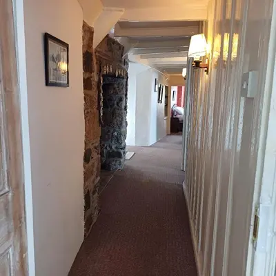 a hallway in a house with a stone wall at The Old Post Office in Coverack