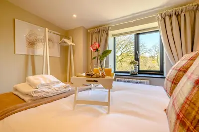 a bedroom with a bed with a table and a window at 2 Bed in Altarnun oc-t31858 in Altarnun