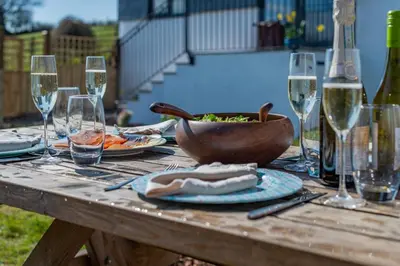 a wooden table with wine glasses and a bowl of food at 2 Bed in Altarnun oc-t31858 in Altarnun