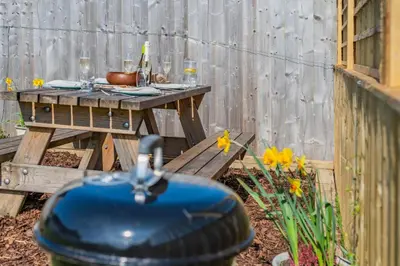 a wooden picnic table in a backyard with flowers at 2 Bed in Altarnun oc-t31858 in Altarnun