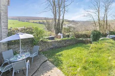 a table and chairs with an umbrella in a garden at 2 Bed in Duloe oc-f31903 in Duloe