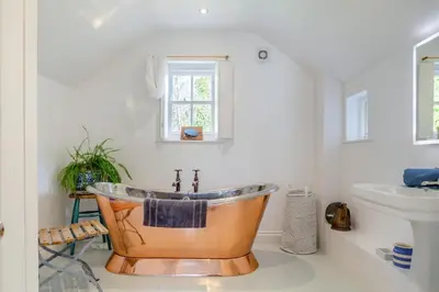 a bathroom with a copper tub and a sink at 3 Bed in St. Teath oc-r31945 in Saint Teath