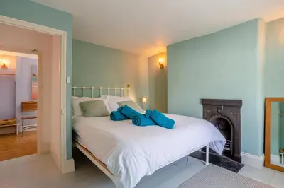 a bedroom with a bed with two blue pillows on it at 3 Bed in St. Teath oc-r31945 in Saint Teath