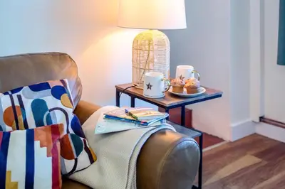 a living room with a chair and a table with a lamp at 1 Bed in Summercourt oc-b31829 in Saint Enoder