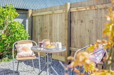 a table and chairs in front of a fence at 1 Bed in Summercourt oc-b31829 in Saint Enoder