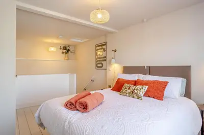 a bedroom with a large white bed with orange pillows at 1 Bed in Summercourt oc-b31829 in Saint Enoder