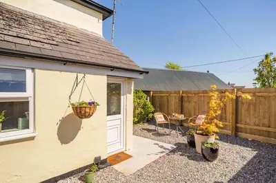 a house with a patio with a table and a fence at 1 Bed in Summercourt oc-b31829 in Saint Enoder
