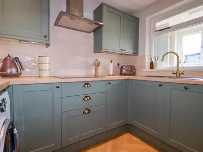 a kitchen with blue cabinets and a sink at Rock View in St Austell