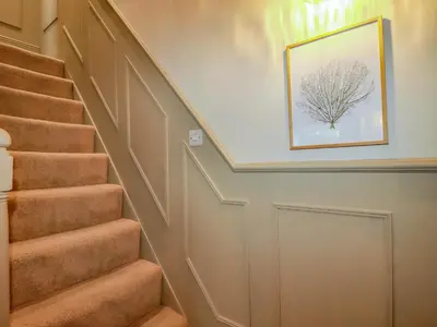 a staircase with a picture of a tree on the wall at Rock View in St Austell