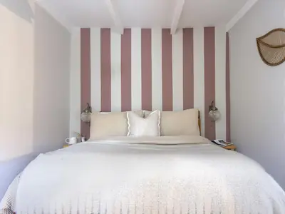 a bedroom with a large bed with striped walls at Rock View in St Austell