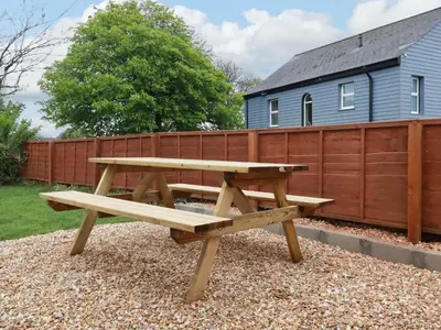 a wooden picnic table in front of a fence at Rock View in St Austell