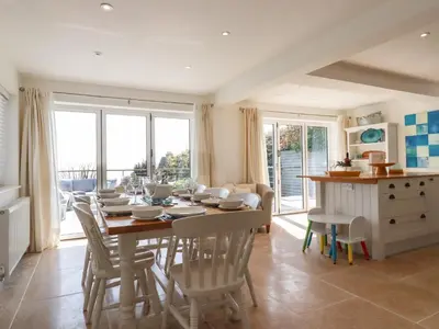 a kitchen and dining room with a table and chairs at The Old Harbour Masters House in Fowey