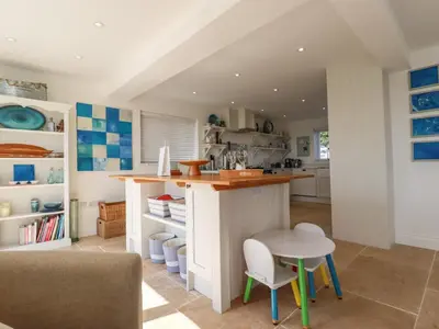 a kitchen with a counter and a table and chairs at The Old Harbour Masters House in Fowey