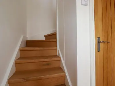 a stairway with wooden stairs with a wooden door at The Old Harbour Masters House in Fowey