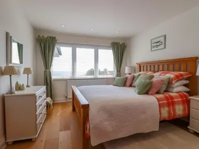 a bedroom with a large bed and a window at The Old Harbour Masters House in Fowey