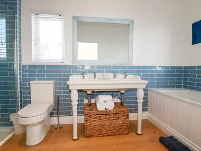 a bathroom with a sink and a toilet and a tub at The Old Harbour Masters House in Fowey