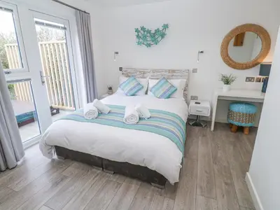 a bedroom with a large bed with towels on it at Petroc in Redruth