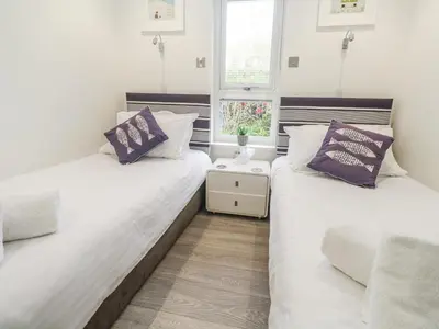 two twin beds in a room with a window at Petroc in Redruth