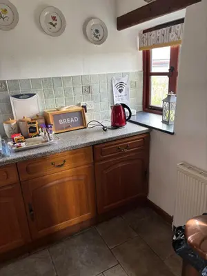 a kitchen with a counter with a red tea kettle at Tregatherall Barn in Boscastle